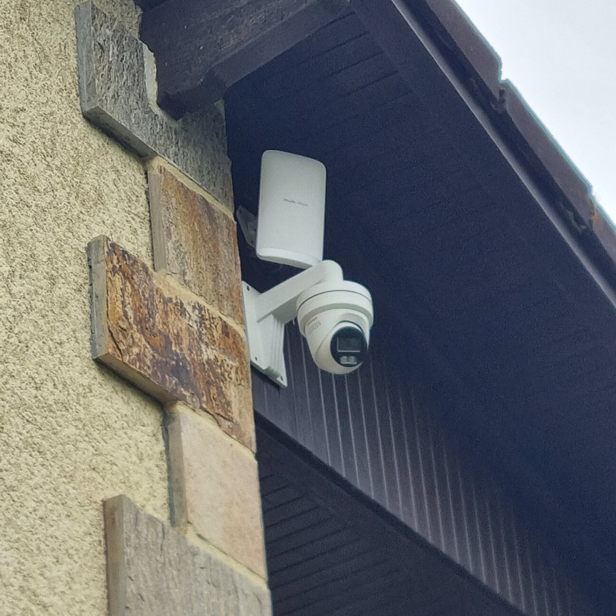 Caméra dôme Hikvision avec spotlight installée sur façade pierres — maison individuelle Dordogne